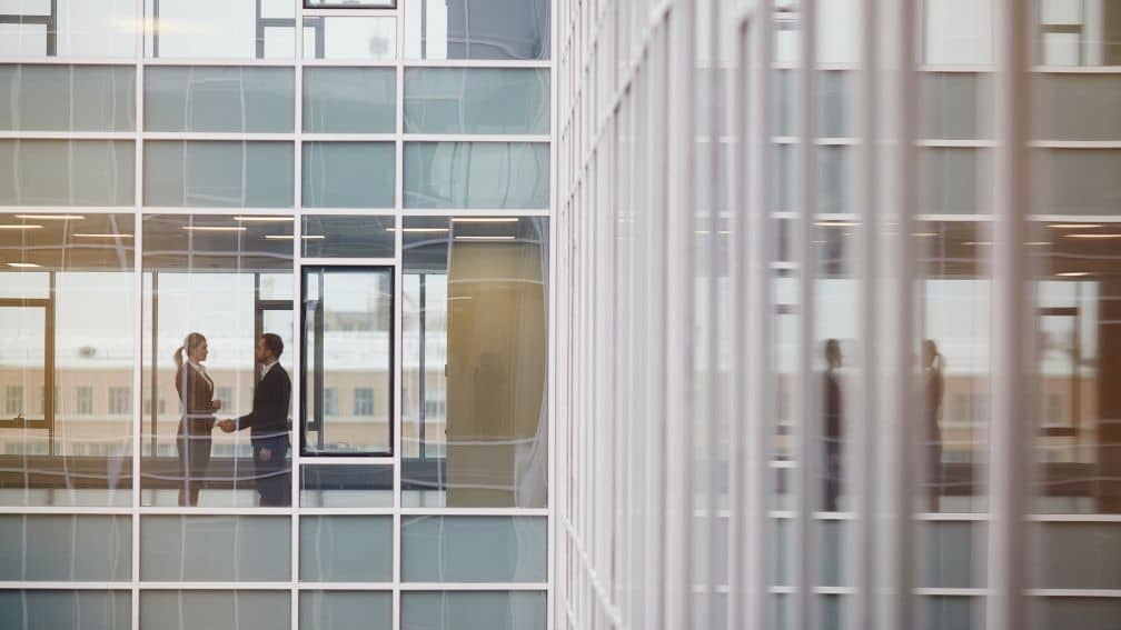 Man and woman shaking hands in a business building