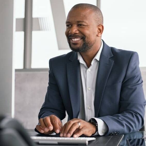 Man smiling while typing at desk